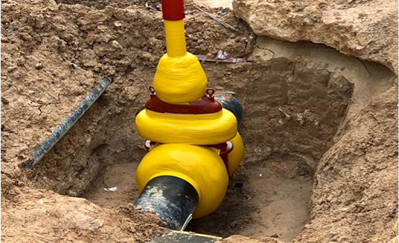 A valve in a trench protected with a petrolatum tape system.