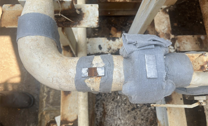 A close up of a metal strip showing visible rusting and corrosion in the area where it wasn't wrapped with the grey ColourTape.
