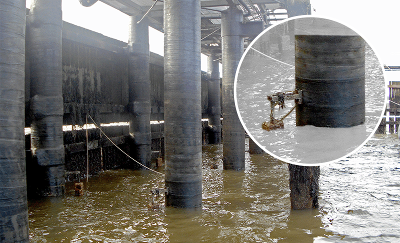 A photo of jetty piles wrapped in a tape, with an inset image showing a closer look at a bracket extending out from the surface of one of the piles, close to the waterline.