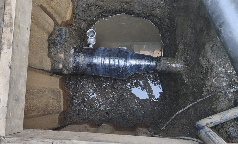 A wrapped casing end in a trench.